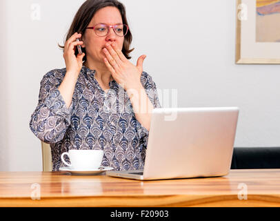 Frau erschrickt am Computer Stock Photo