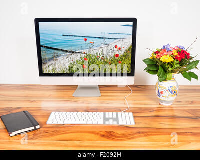 Computer und Blumen auf einem Tisch Stock Photo