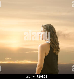 Young woman looking away at sunset Stock Photo