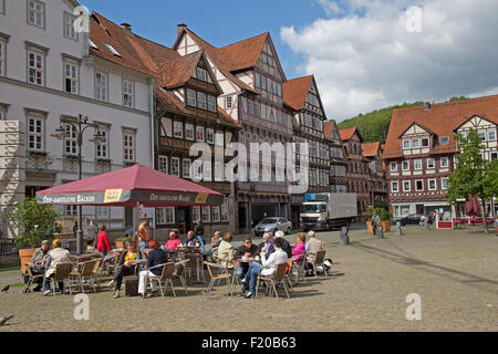 People sitting outside cafe in city square half timbered houses Hann Munden Germany Stock Photo