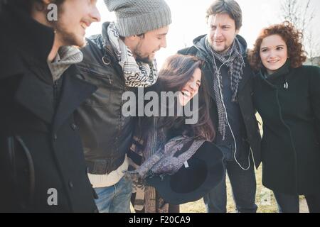 Five young adult friends laughing together in park Stock Photo
