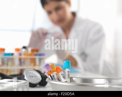 Female doctor inspecting blood sample at desk