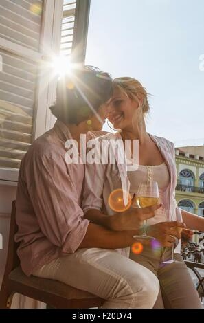 Romantic young couple drinking wine on restaurant balcony in Plaza Vieja, Havana, Cuba Stock Photo