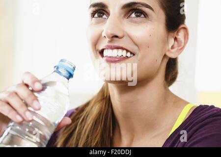 Close up portrait of young woman taking an exercise break drinking water Stock Photo