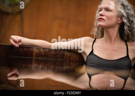 Mature woman sitting in hot tub at eco retreat Stock Photo