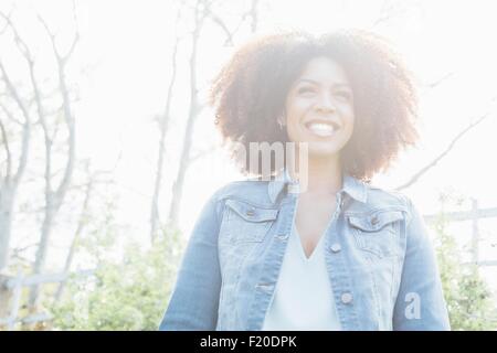 Low angle view portrait of mid adult woman in sunlight, smiling looking away