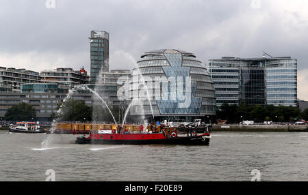 London, Britain. 9th Sep, 2015. A ship sprays water in a procession on the River Thames to mark the day on which Queen Elizabeth II becomes the longest reigning monarch in British history, in London, Britain, on Sept. 9, 2015. Wednesday marks the 63 years and 216 days since the Queen came to the throne. The procession began from east of Tower Bridge at midday, with the vessels sounding their horns for one minute. Also, the Tower Bridge lifted as a sign of respect. Credit:  Han Yan/Xinhua/Alamy Live News Stock Photo