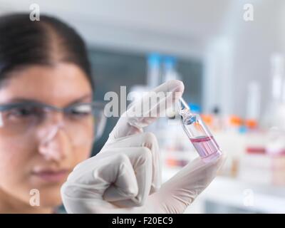 Female scientist testing medical drug ampule in laboratory Stock Photo