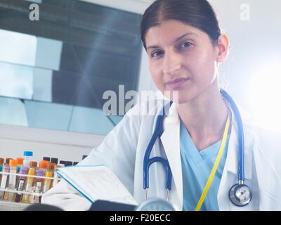 Portrait of female doctor reading medical notes in hospital Stock Photo