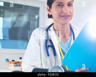 Portrait of female doctor holding medical notes in hospital Stock Photo