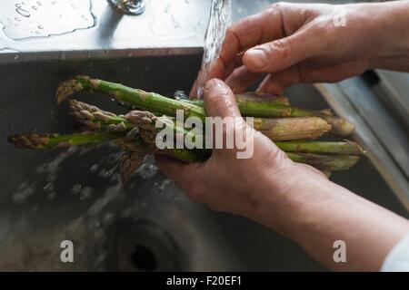 Washing asparagus, focus on hands Stock Photo