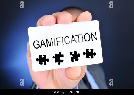 young caucasian man in suit shows a signboard with the word gamification written in it Stock Photo