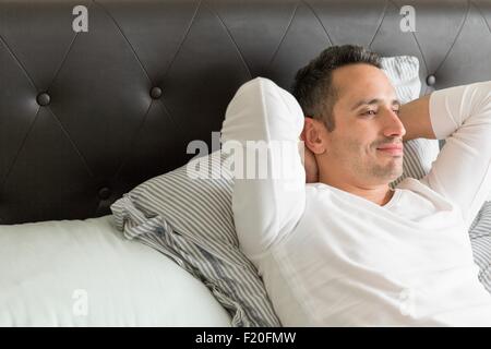 Mid adult man relaxing on bed Stock Photo