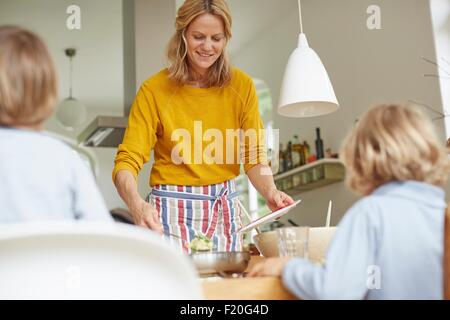 Woman serving meal at dining table Stock Photo