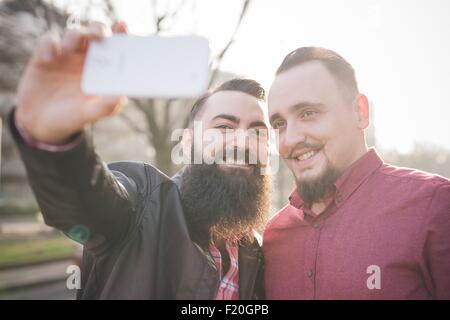 Gay couple taking selfie on pavement Stock Photo