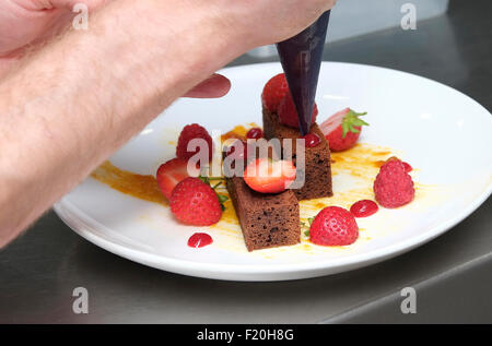 chef putting finishing touches to sweet dessert Stock Photo