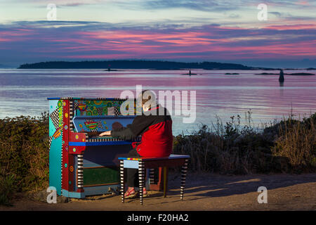 Senior citizen woman playing colorful piano at pre sunrise-Victoria, British Columbia, Canada. Stock Photo