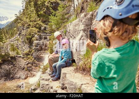 Father and children taking photograph on hill, Ehrwald, Tyrol, Austria Stock Photo
