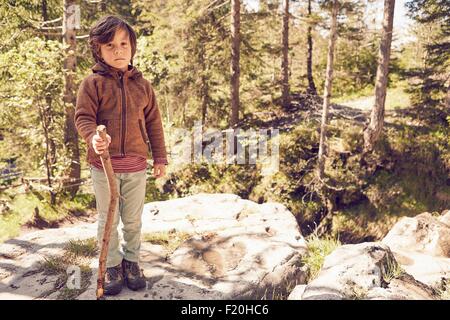 Portrait of young boy in forest, standing on rock Stock Photo