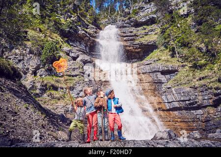 Group of children exploring by waterfall