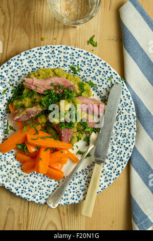 Ham hock with split peas and carrots. a UK lunch dinner meal cooking cuisine plate dish Stock Photo