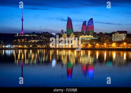 Azerbaijan, Baku, Baku Bulvar (Boulevard), city illuminated at dusk reflected in the Caspian sea, the Flame Towers with the colours of the national flag and the TV Tower Stock Photo