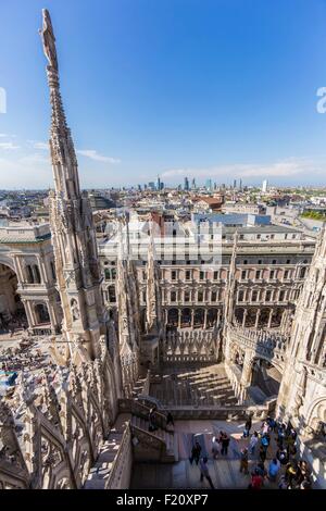 Italy, Lombardy, Milan, the arrows and statues of Duomo seen since the terrace situated on the roof of the cathedral with a view of the gallery Vittorio Emanuele II and the district Porta Nuova with its skyscrapers Stock Photo