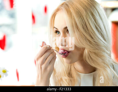 Very beautiful young woman, sit in  Cafe and eating dessert, closeup portrait Stock Photo