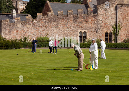 Elderly people playing croquet on the lawn,  the Bishop's Palace, Wells, Somerset UK Stock Photo