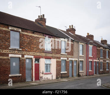 House with red door, the only occupied house in street of boarded up houses in Middlesbrough, England, UK Stock Photo