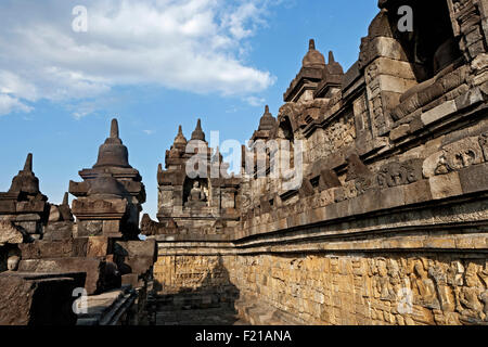 Indonesia, Java, Borobudur, Upper gallery, showing seated Buddhas in niches and bas-reliefs along the walls. Stock Photo