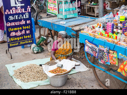 Local woman in a sari selling apples and peanuts on the roadside, typical street scene, Chidambaram, Tamil Nadu, southern India Stock Photo