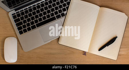 Laptop and mouse, opened Notepad with pen on a wooden Desk top view. Stock Photo