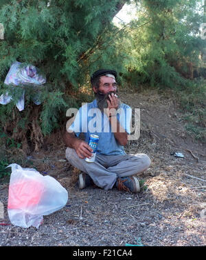Homeless man smoking and drinking Stock Photo