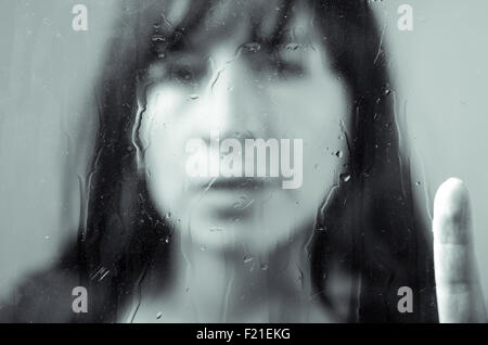 Closeup portrait of brunette girl behind glass Stock Photo