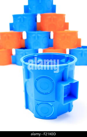 Blue and orange plastic electrical boxes on white background, components for use in electrical installations, Stock Photo