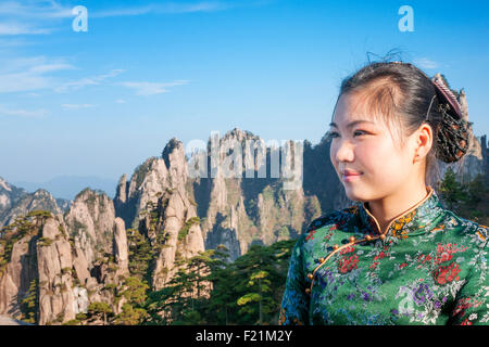 Chinese female in traditional floral dress admires views of jagged peaks, North Sea vista, Yellow Mountain, Huang Shan Stock Photo