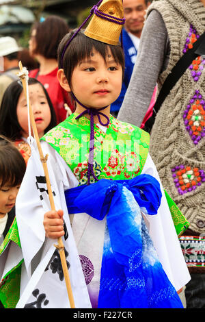 Genji Tada shrine festival. Parade of children dressed in Heian period costume. Young boy, 6-8 year old, with gold hat, white robe and green jacket. Stock Photo