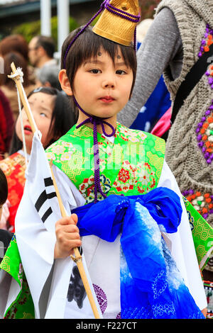 Genji Tada shrine festival. Parade of children dressed in Heian period costume. Young boy, 6-8 year old, with gold hat, white robe and green jacket. Stock Photo