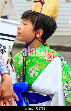 Genji Tada shrine festival. Parade of children dressed in Heian period costume. Young boy, 6-8 year old, with gold hat, white robe and green jacket. Stock Photo