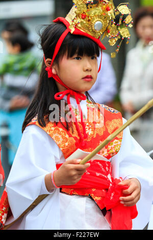 Genji Tada shrine festival. Parade of children dressed in Heian period costume. Young girl, 6-8 year old, with gold crown, white robe and red jacket. Stock Photo