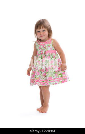 Charming little girl in a bright dress with a floral pattern. Isolate on white. Stock Photo