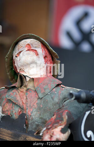 Injured German mannequin in front of a Nazi Swastika flag Stock Photo