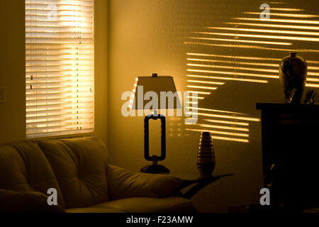 Living room wall illuminated by sunlight at late afternoon through a window blond. Stock Photo