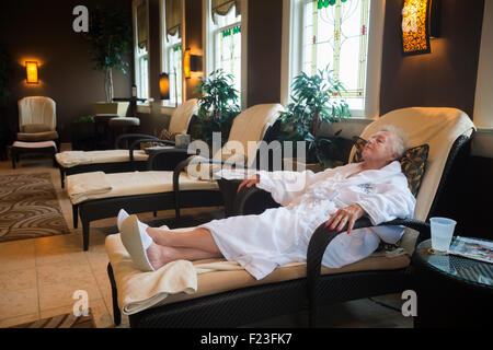 Senior Caucasian woman relaxes in a  lounge chair at the spa in French Lick Resort, Indiana, USA Stock Photo