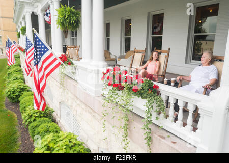 Two Caucasian women, grandmother and granddaughter, sitting in rocking chairs on the porch of the historic French Lick Springs Stock Photo