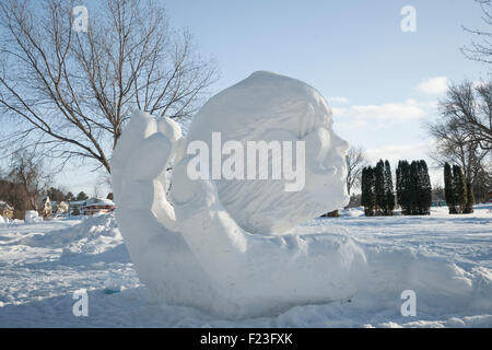 Snow sculpture of a head in a curved hand at the winter tracks festival in Ely, MN, USA Stock Photo