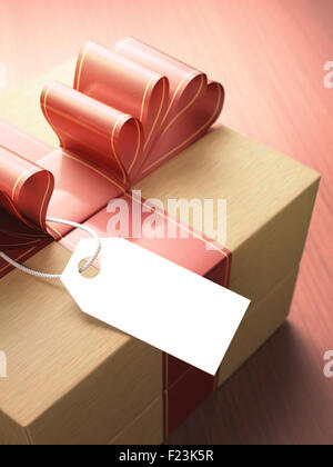 Gift with red ribbon and a blank card waiting for your message. Depth of field with focus on the card. Clipping path included. Stock Photo
