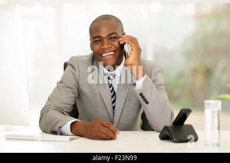 cheerful young African business man talking on mobile phone Stock Photo