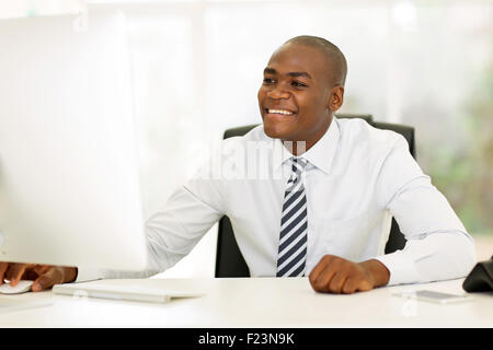 smiling young afro American businessman using computer Stock Photo